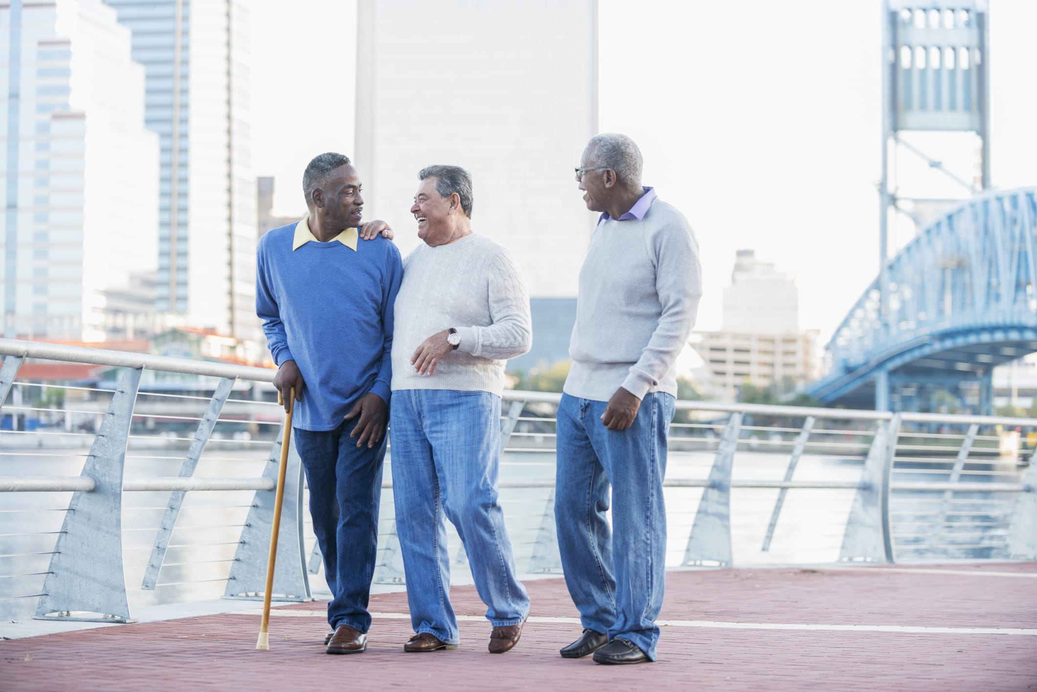 three friends walking along a downtown boardwalk laughing