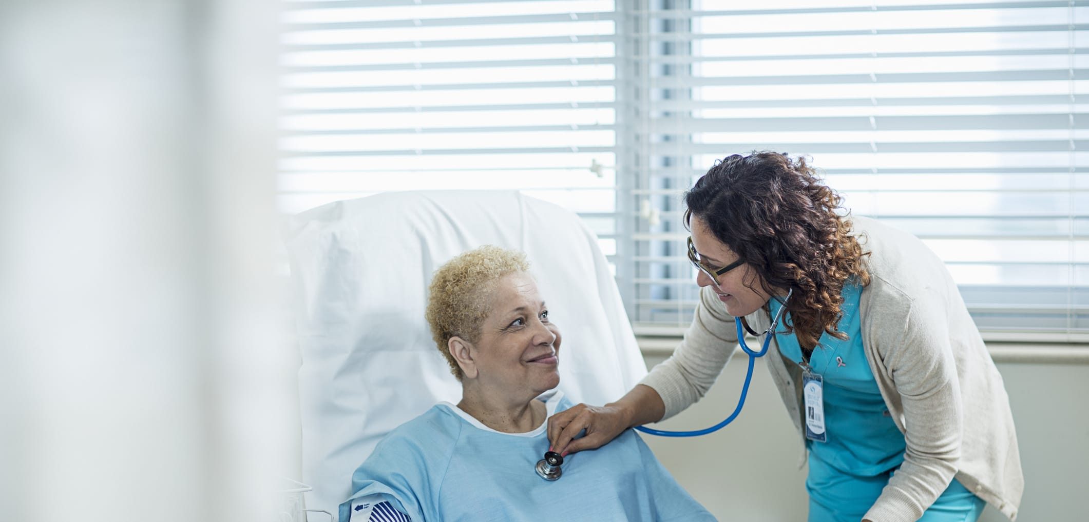 Doctor using a stethoscope to listen to a patient’s heartbeat during a medical exam.