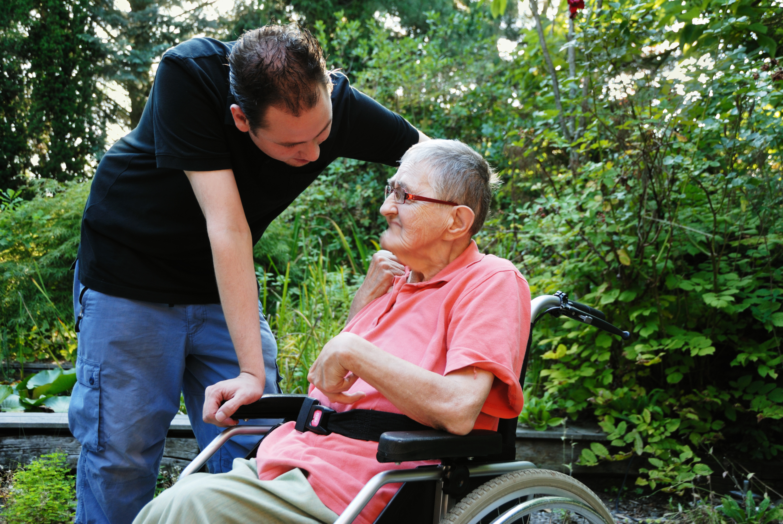 individual with severe spasticity in a wheelchair outside with family member