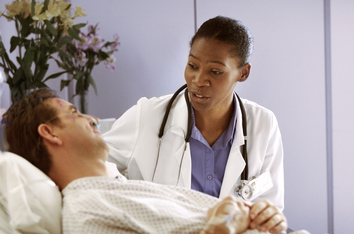 nurse talking to patient in hospital bed